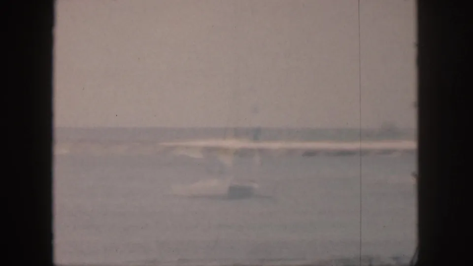 A faded 1959 Hawaii coastal view shows surf and a hazy shoreline divided by dark window-frame bars.