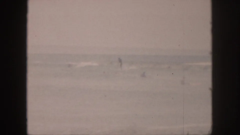 A faded 1959 Hawaii ocean view shows distant white surf and pale water behind dark window mullions.