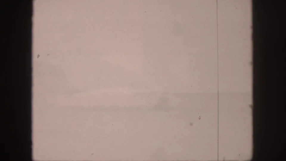 1959 Hawaii 8mm frame with misty water, faint mountain silhouettes, pale sky, and dark film-edge borders.