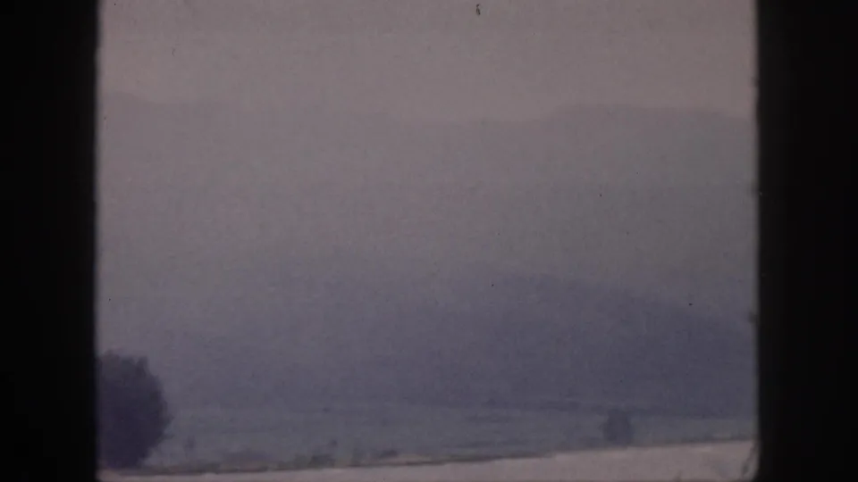 1959 Hawaii 8mm frame showing a muted, misty landscape and distant hills divided by dark window or frame bars.