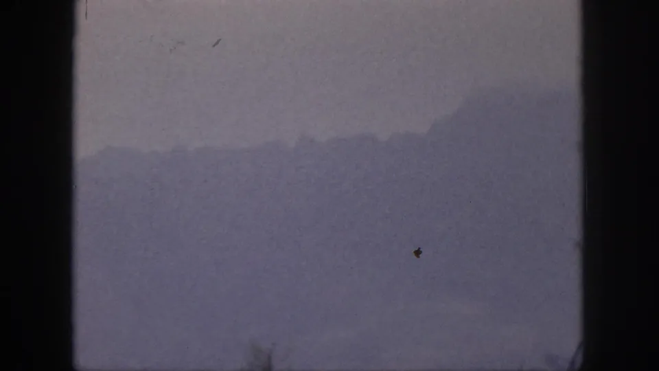 1959 Hawaii 8mm frame showing layered mountain silhouettes partly obscured by atmospheric haze.