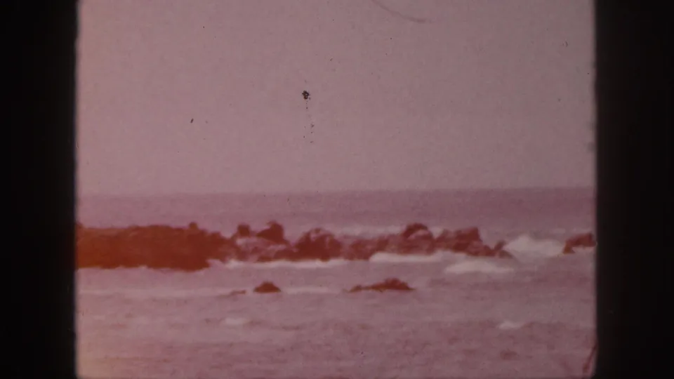 Faded 1959 Hawaii 8mm view of rocks, surf, and horizon with no clear people in this sampled frame.