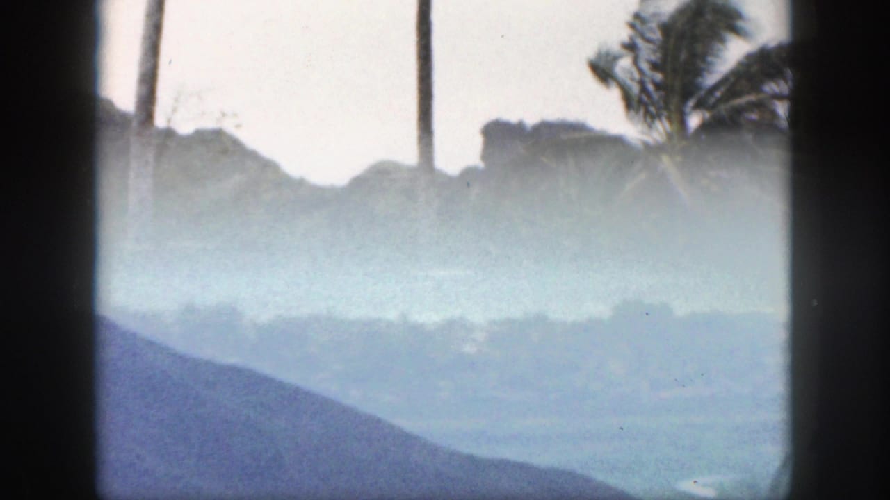 Hazy mountain and valley view through dark vertical framing.