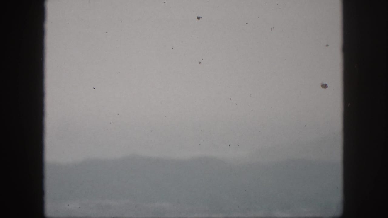 A foggy Hawaii hill view from 1959, with distant slopes partly obscured by mist and film grain.