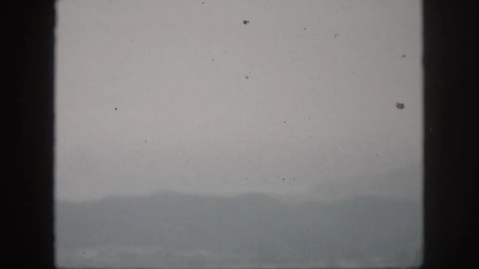 A foggy Hawaii hill view from 1959, with distant slopes partly obscured by mist and film grain.