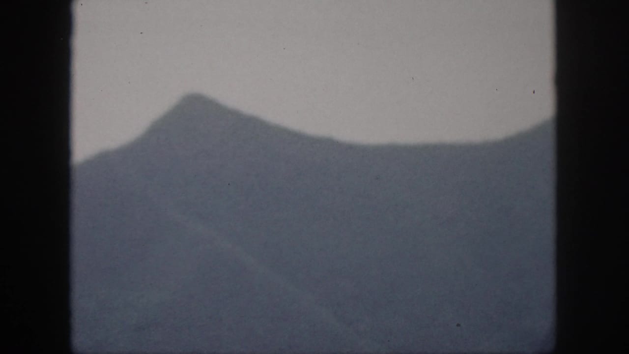 Distant mountain ridge with a pointed peak and soft blue-gray haze.