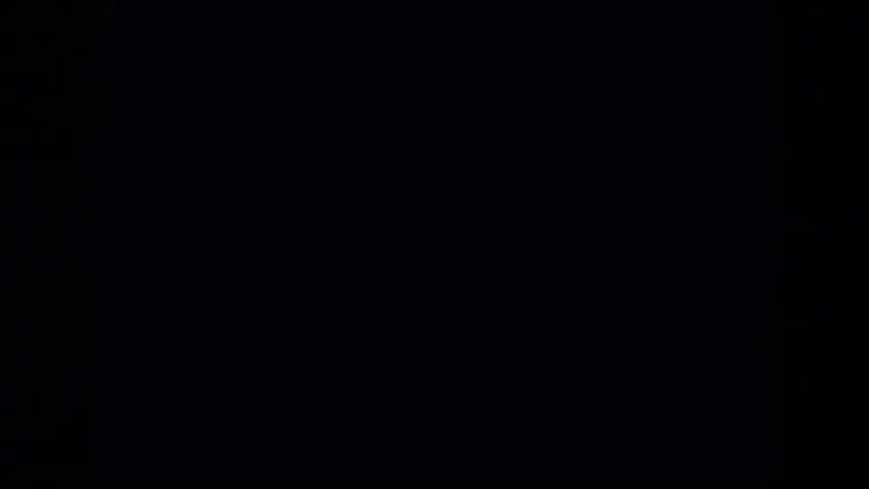 Near-blank dark section of the 1959 8mm clip, showing faint color noise and film texture rather than a visible scene.