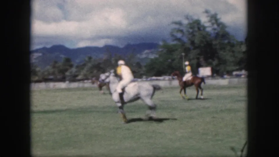 1959 Oahu polo footage with a rider on a gray horse in the foreground and other mounted players near the field edge.
