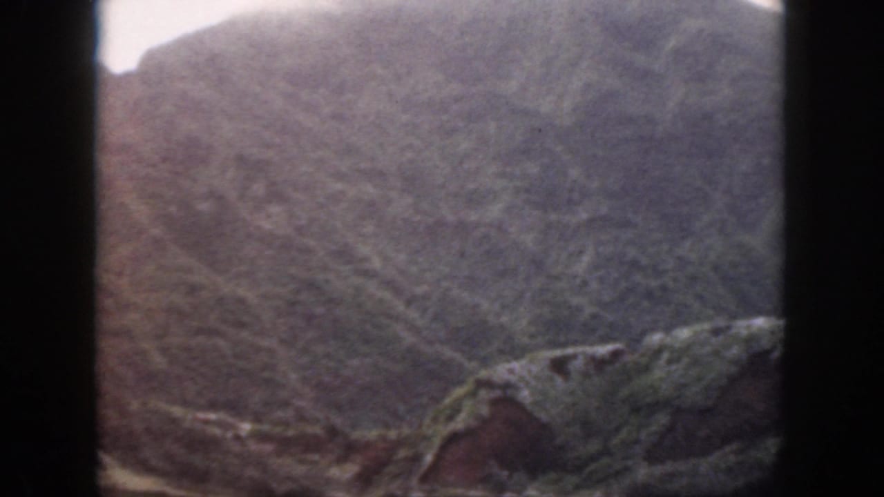 1959 Oahu 8mm frame showing a steep rocky hillside with limited vegetation and soft, faded color.