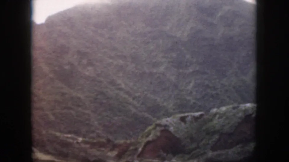 1959 Oahu 8mm frame showing a steep rocky hillside with limited vegetation and soft, faded color.
