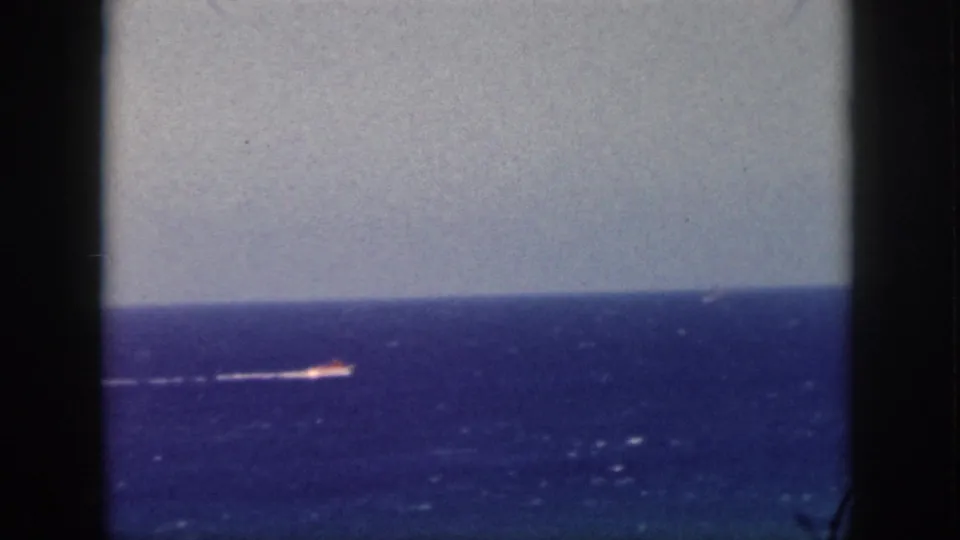 1959 Oahu 8mm frame with a far-off vessel and white wake crossing the ocean horizon.