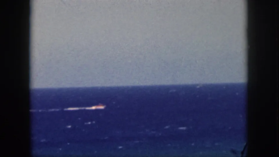 1959 Oahu 8mm frame showing the boat farther along the horizon, with soft focus and visible film texture.