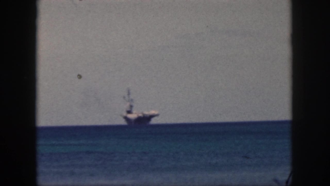 Distant ship on a blue ocean horizon, divided by a vertical dark frame.