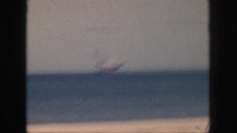 1959 Oahu 8mm frame with the distant ship softened by focus and haze above the ocean horizon.