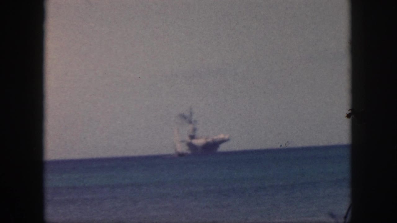 1959 Oahu home-movie frame showing a distant naval-looking ship on a blue ocean horizon under a hazy sky.