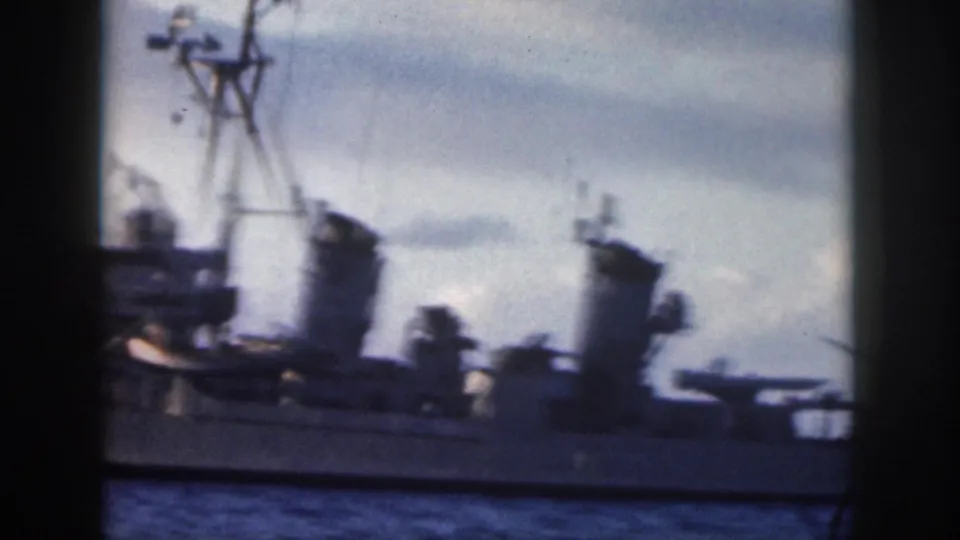 1959 Oahu 8mm frame showing a blurred close view of Navy ship masts, deck equipment, and hull through foreground framing.