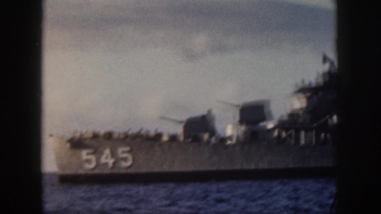 Warship bow and hull number 545 visible on the ocean.