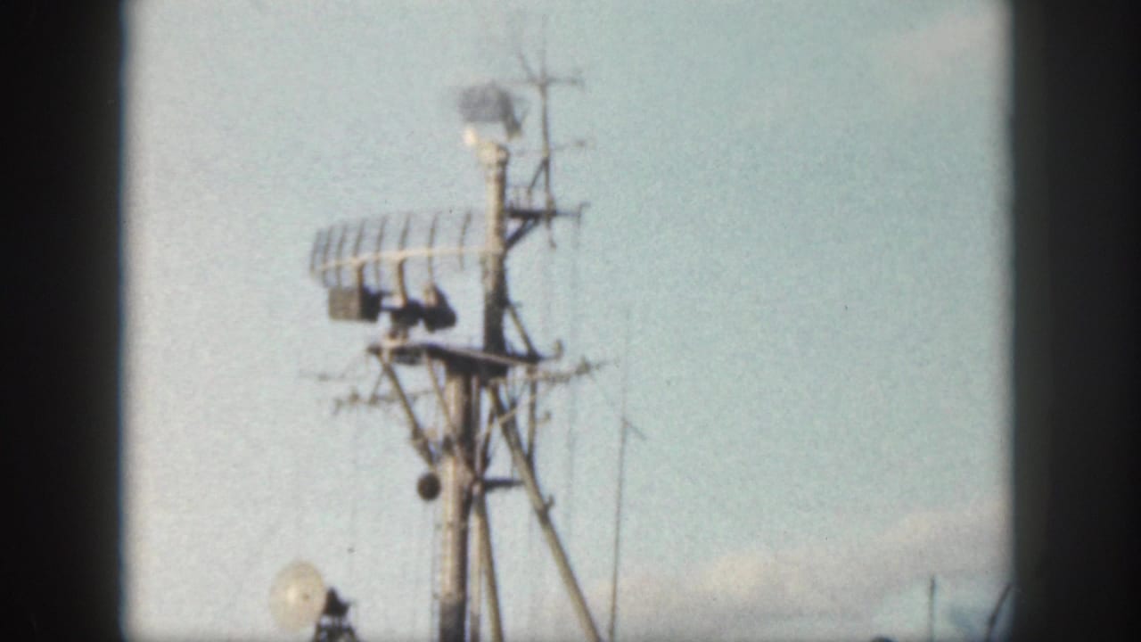 1959 Oahu home-movie frame showing radar equipment and antennas on a military ship at sea.