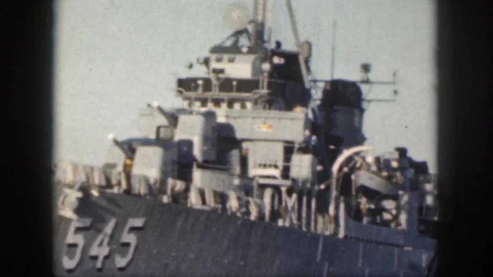 1959 Oahu frame showing a gray military ship with hull number 545, superstructure, gun mounts, and deck railings.