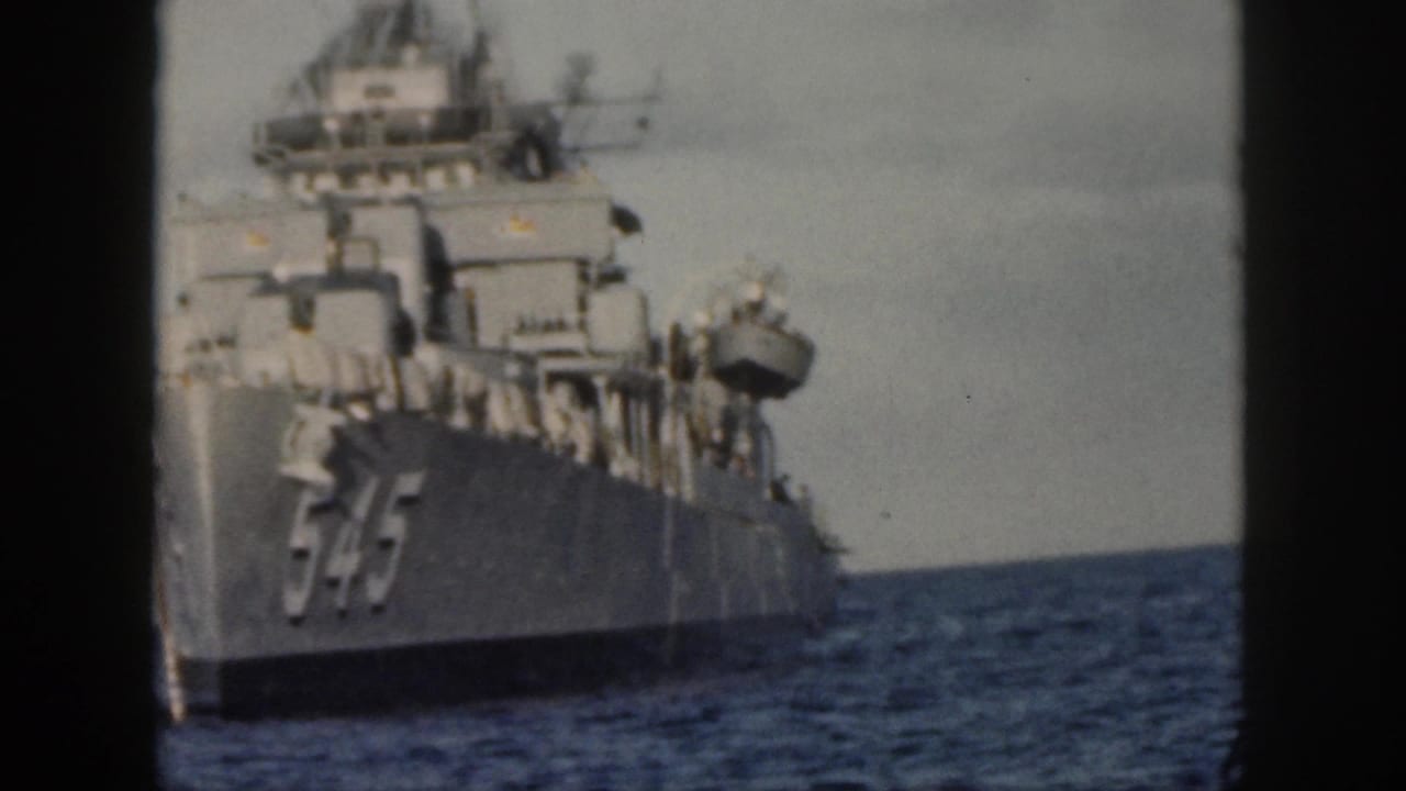 Naval ship 545 angled across the water with horizon behind it.