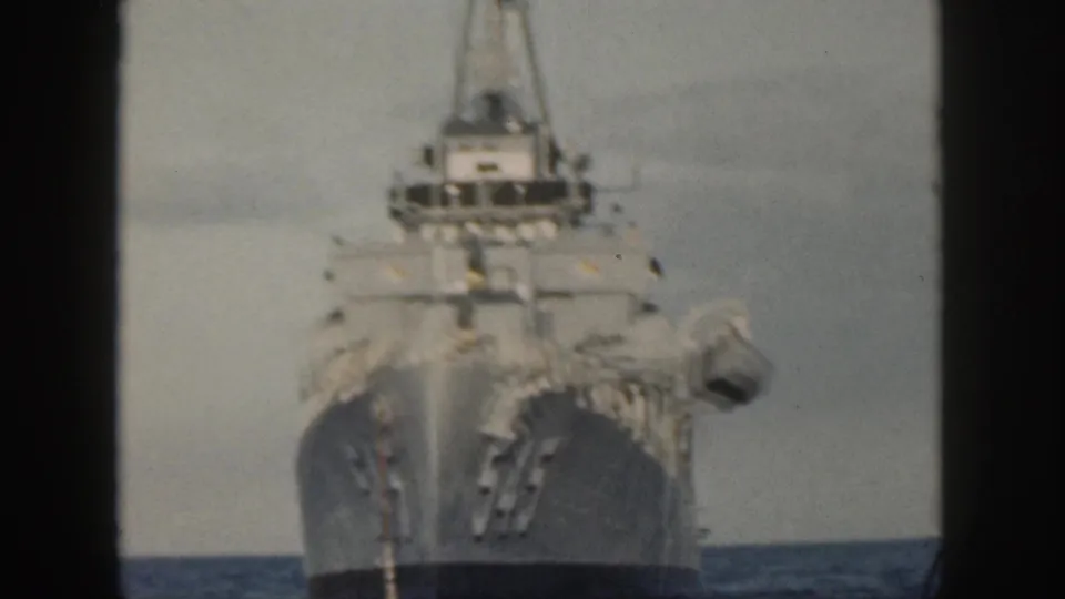 1959 Hawaii 8mm frame showing naval ship 545 head-on, with deck lines and superstructure softened by film grain.