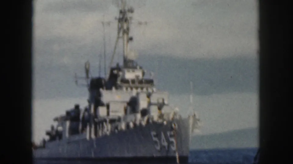 1959 Oahu frame showing the bow of a U.S. Navy destroyer marked 545, with mast, deck fittings, and sea visible around it.