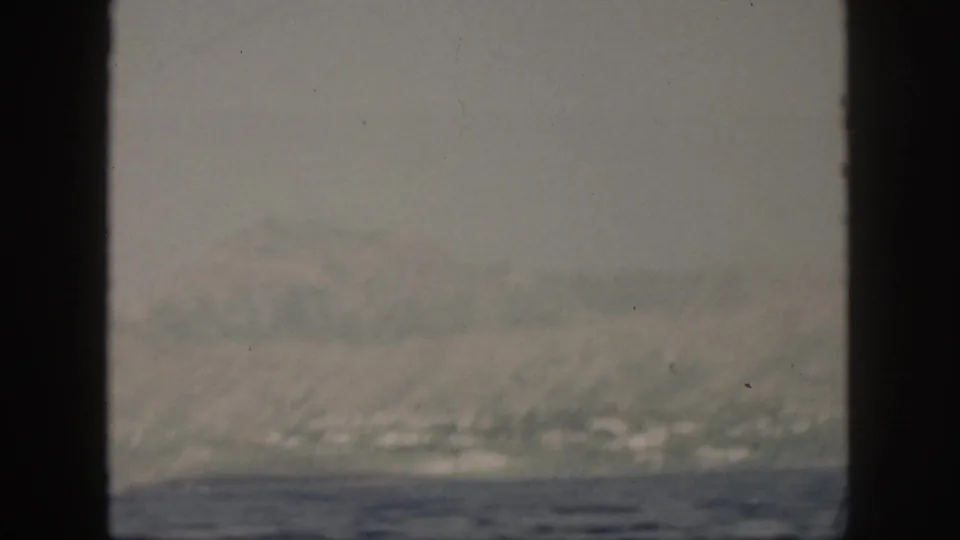 Soft 8mm view of the sea off Oahu in the 1959 home-movie clip, framed by dark boat structure.