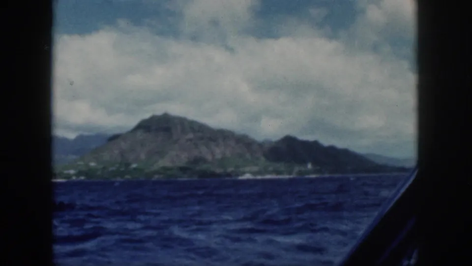 Diamond Head and the Oahu coastline appear beyond the ocean, filmed from a moving boat in 1959.
