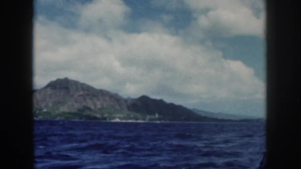 The Oahu coast and Diamond Head fill the background while dark boat framing cuts through the foreground.