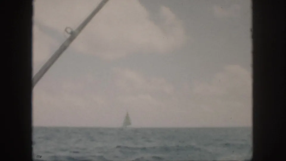 The 1959 Oahu sea view holds on a faint sailboat, cloudy sky, and diagonal boat hardware in the foreground.