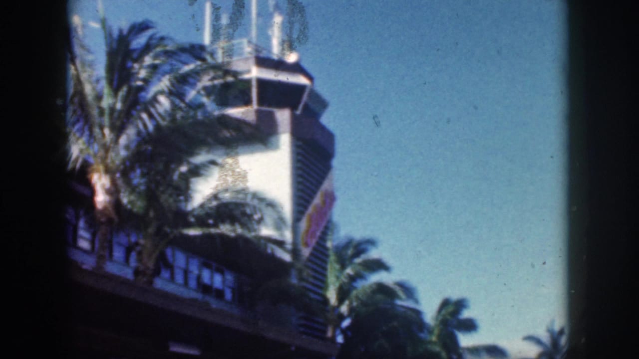 Control tower and palm trees seen from a low angle beside the terminal.