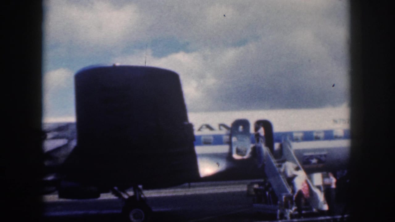 Aircraft tail and fuselage frame passengers boarding through an open door with mobile stairs.
