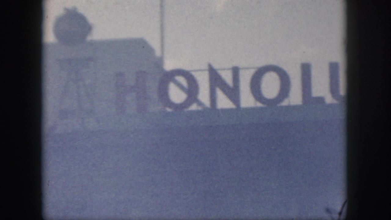 Soft 8mm frame showing a partially visible Honolulu sign, supporting the Hawaii location metadata.