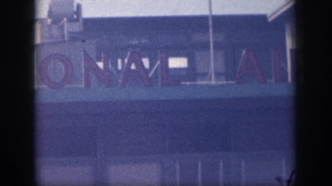 Partial international airport letters across a blue building facade.