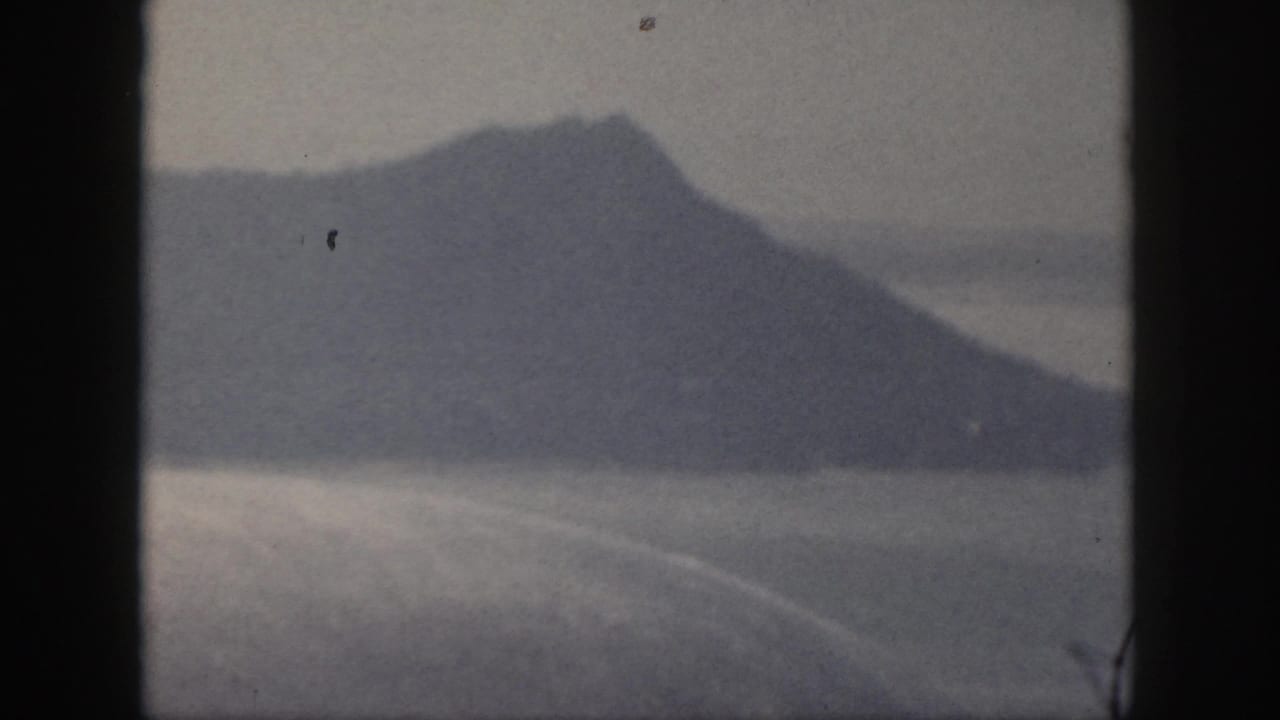 Distant mountain ridge across water with dark borders and a small speck above the peak.