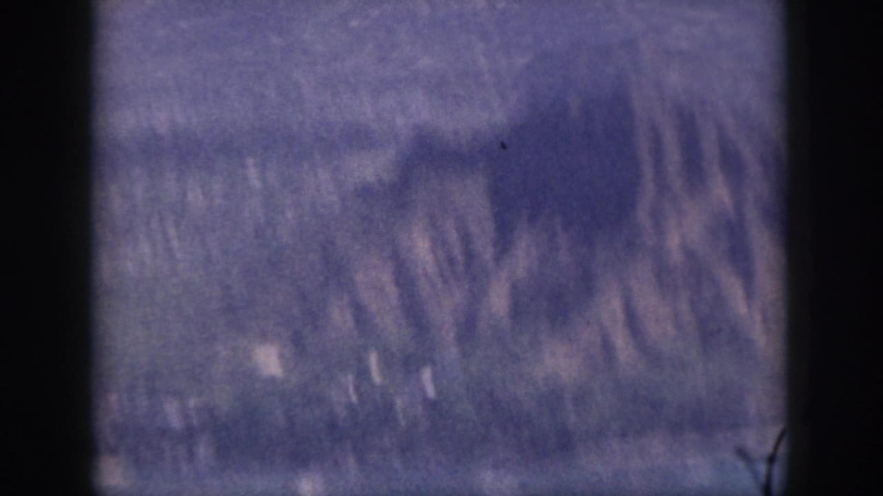 1959 Oahu 8mm frame showing blurred mountain ridges through a dark vertical foreground edge.