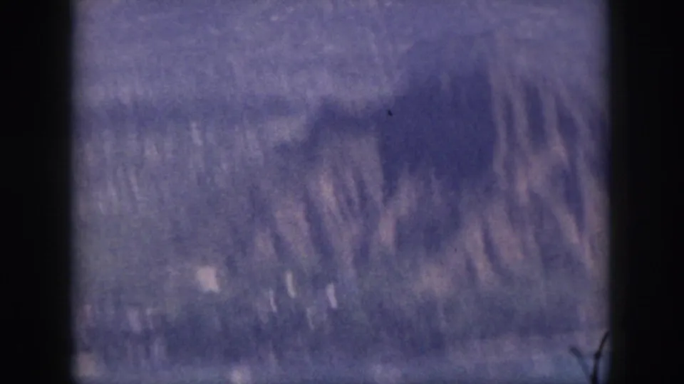 1959 Oahu 8mm frame showing blurred mountain ridges through a dark vertical foreground edge.