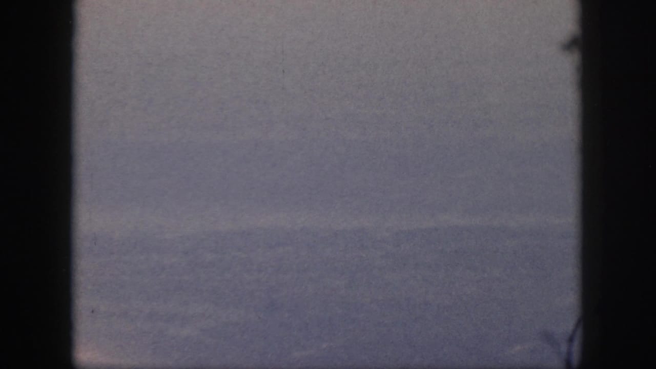 Blue ocean and sky divided by a low horizon with dark frame edges.