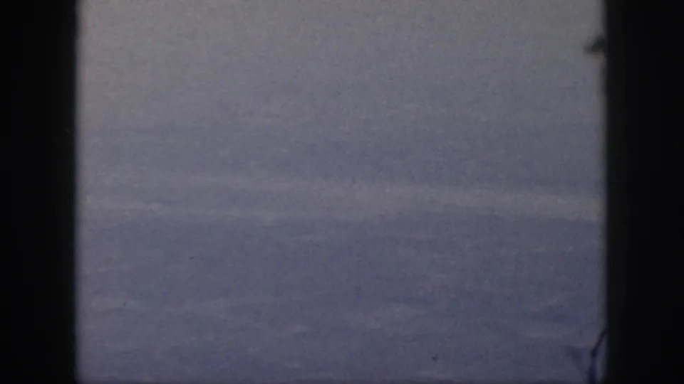 1959 Oahu 8mm frame with dense mist over a distant valley and dark gate-like borders on both sides.