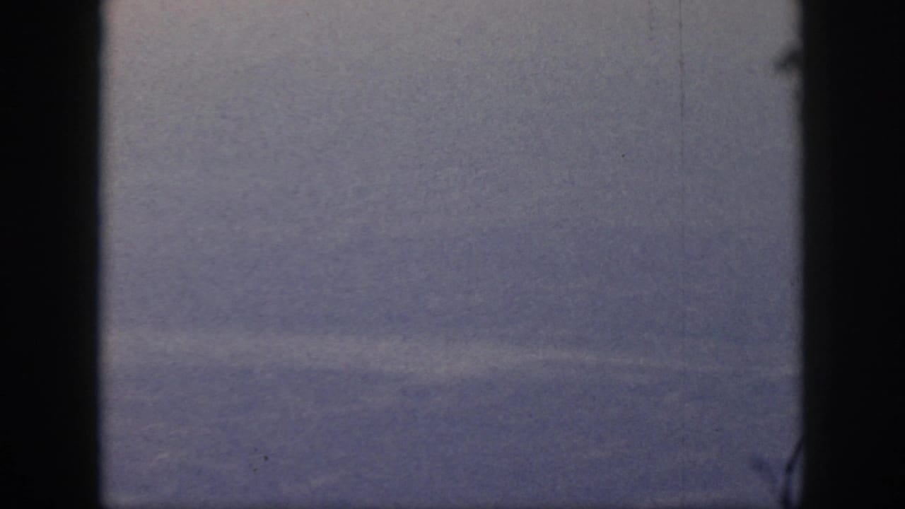 1959 Oahu 8mm frame showing a fog-shrouded valley or forested slope, held in a static composition with dark edge borders.