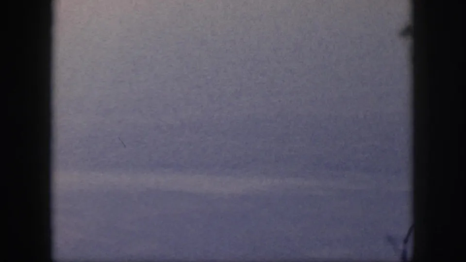 Hazy blue sky in 1959 Oahu travel footage, partly obscured by a dark vertical window or film-frame strip.