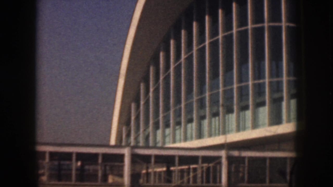 1959 Oahu airport exterior showing a mid-century terminal facade with curved glass bays and an arched roofline.