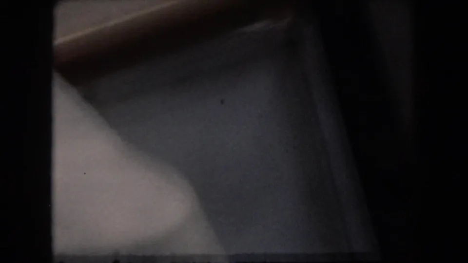 Closing 1961 Grand Rapids home-movie frame with a partial close view of water and dark 8mm frame border after the skiing pass.