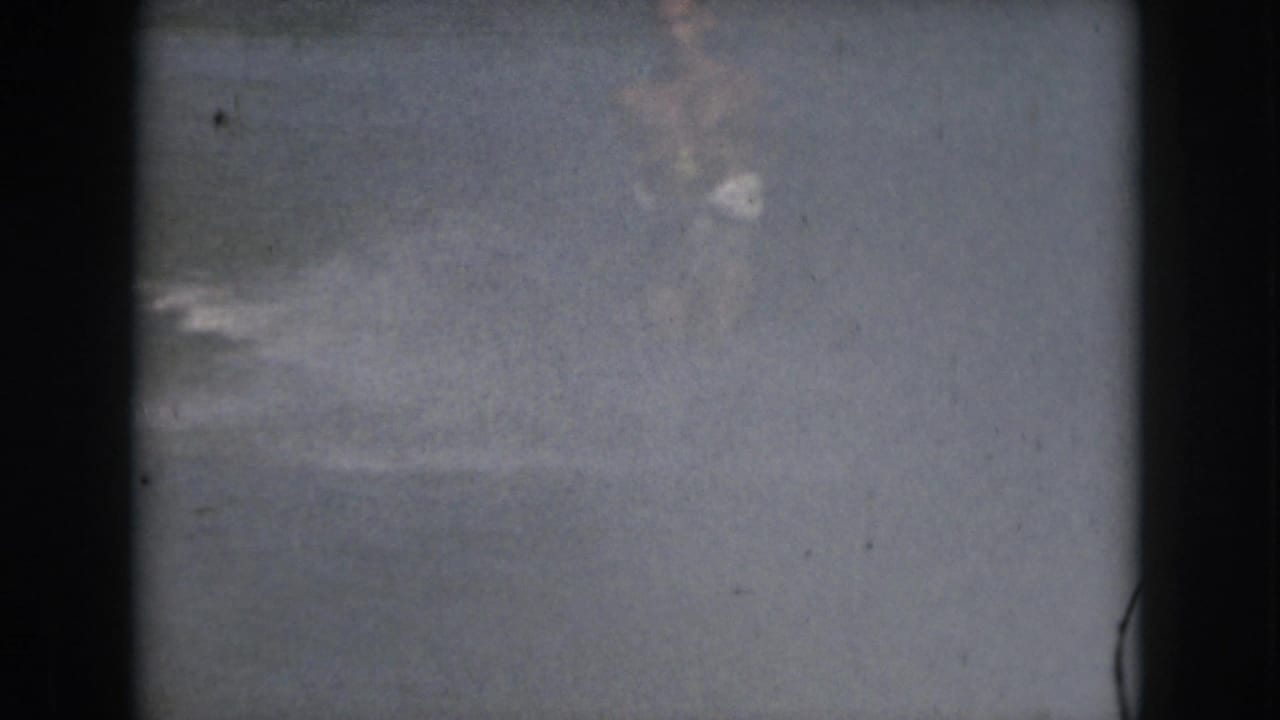 Open water and film-frame border with the skier mostly outside the visible frame.