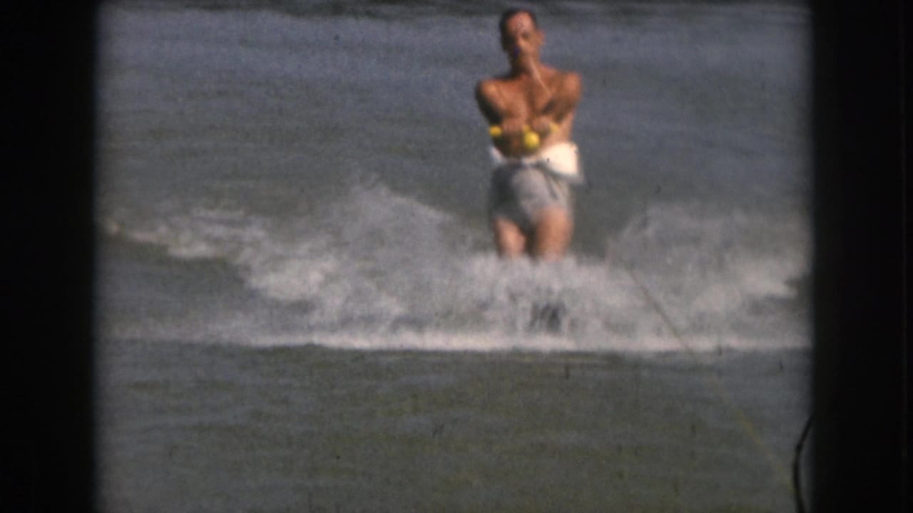 Water skier holding a tow handle while crossing the lake surface.