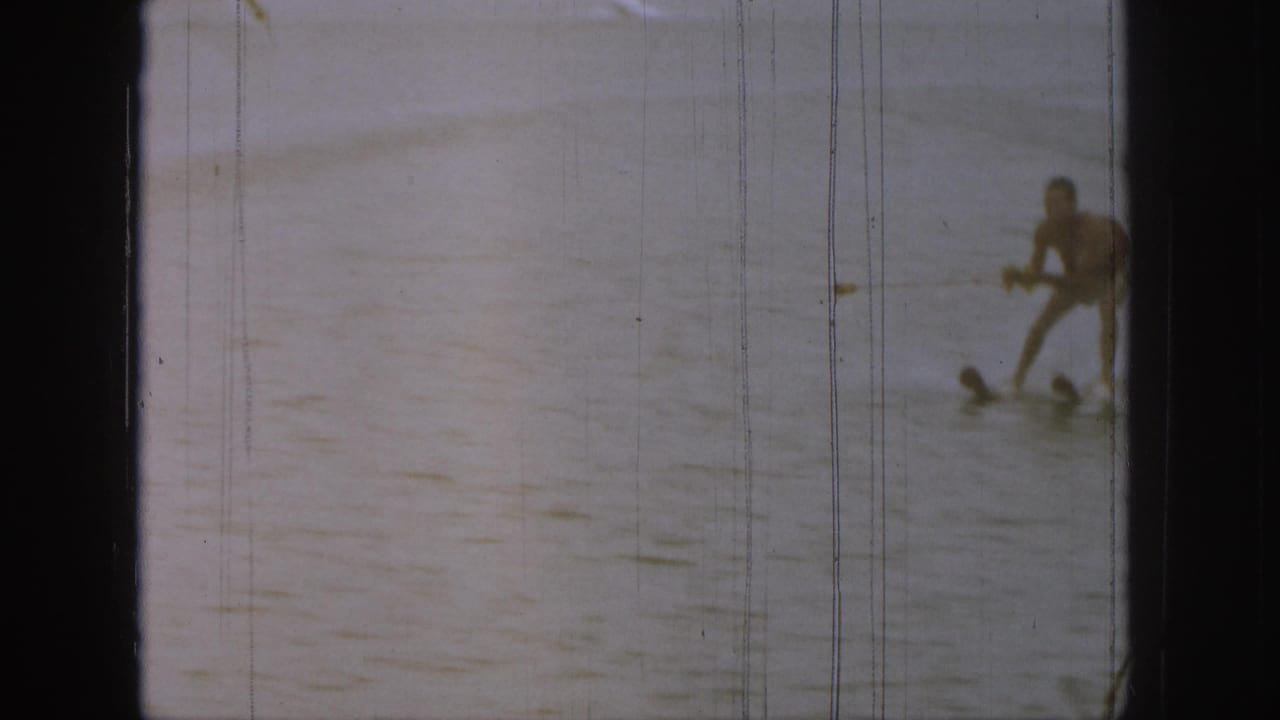 Water skier crouched low on the lake while being pulled forward.