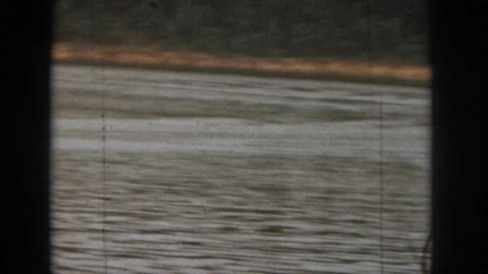 1961 Michigan 8mm frame showing lake water and a distant wooded shore after the skier has moved out of the visible area.