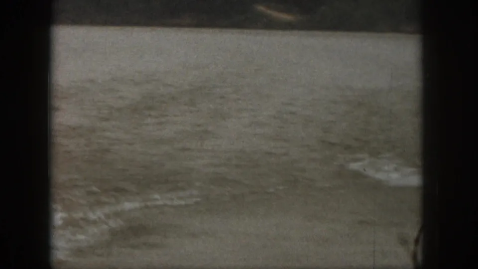 Final 1961 Michigan home-movie frame with the skier out of view and only rippled lake water and foam remaining.
