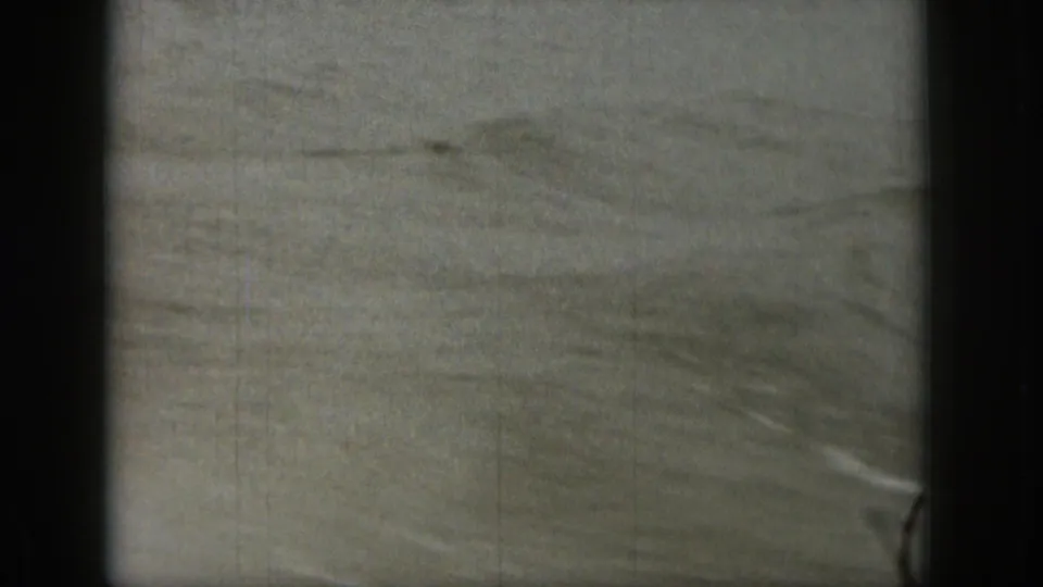 1961 Michigan 8mm frame showing choppy lake water in soft focus with visible film gate borders.
