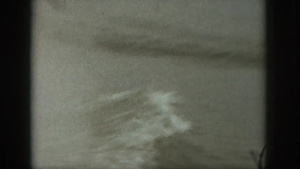 Soft 8mm frame of choppy Michigan water with a blurred patch of wake or spray crossing the surface.